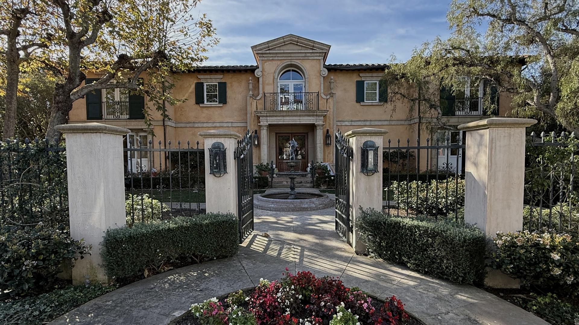 The gated entrance and forecourt of a Southern California estate, photographed from the drive